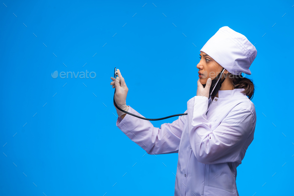 Young Nurse In White Uniform Checks The Patient With Stethoscope Stock